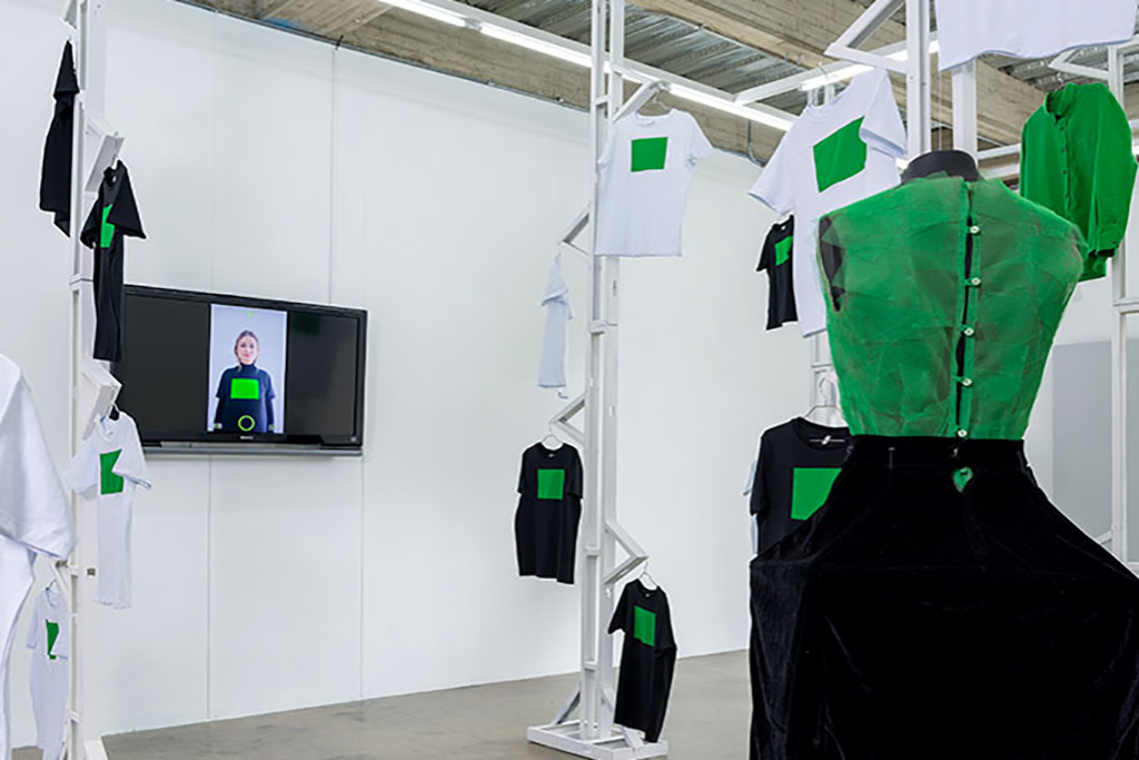close up of again's first floor installation, tv screen showing a person with one of the tshirts shown in the exhibition
