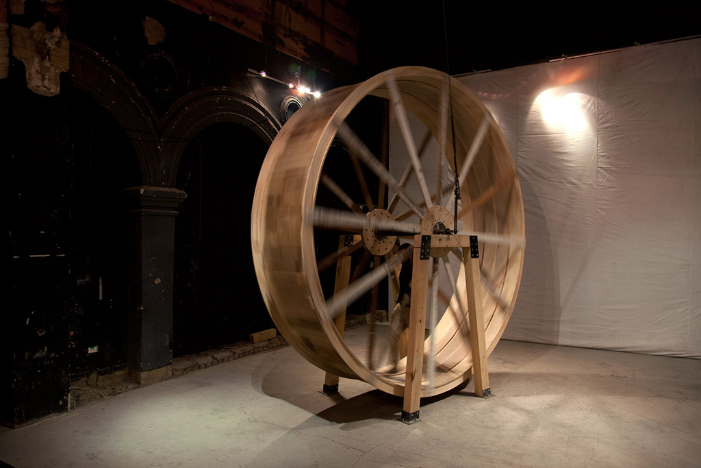 Big scale wooden wheel with a person walking inside it