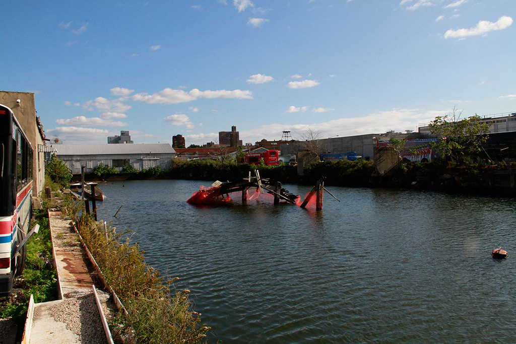 General shot of a sunken dock with the art intervention. The dock is in the middle of the Gowanus Canal in Brooklyn New York