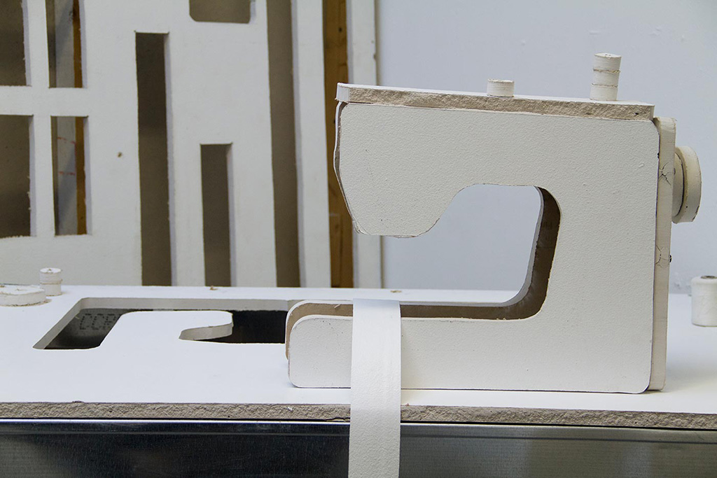 Closer view of a sewing machine made out of sheetrock.